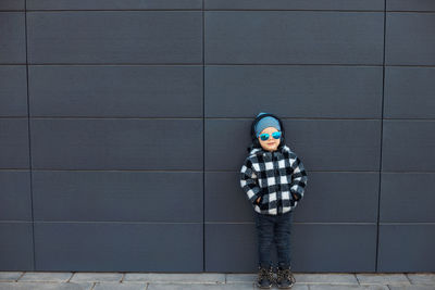 Boy standing against blue wall