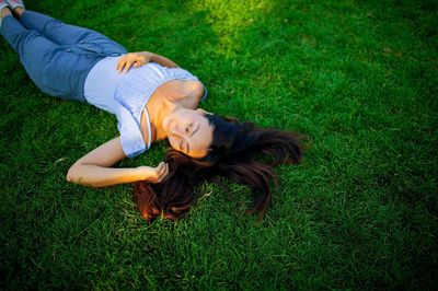 High angle view of woman sitting on grassy field