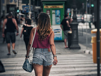 Rear view of woman walking on street in city