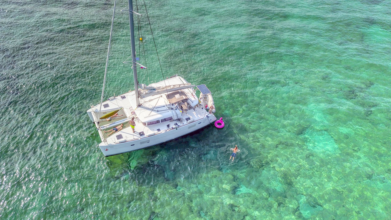 HIGH ANGLE VIEW OF SAILBOAT MOORED IN SEA