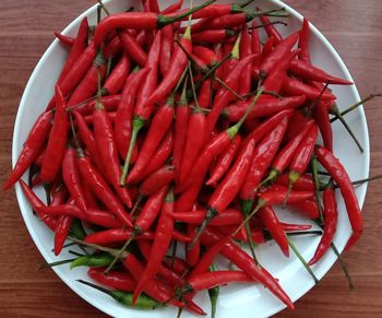 High angle view of red chili peppers in plate on table