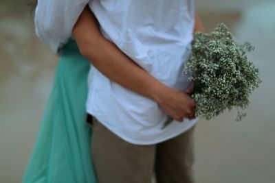 Midsection of couple embracing at beach