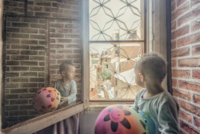 Boys playing by window at home