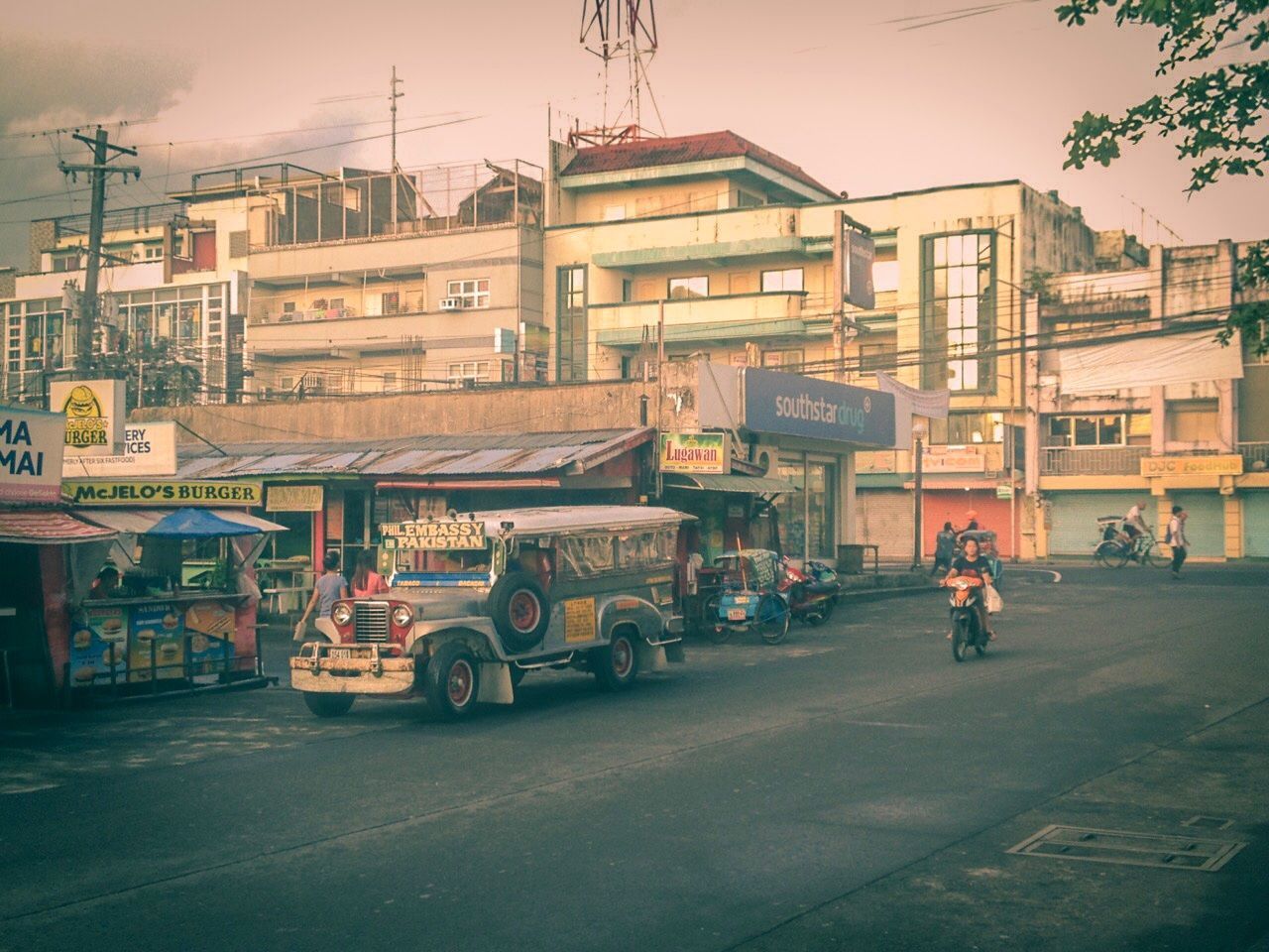 transportation, mode of transportation, architecture, building exterior, land vehicle, city, street, built structure, motor vehicle, car, road, incidental people, real people, city street, city life, sky, outdoors, men, people, nature