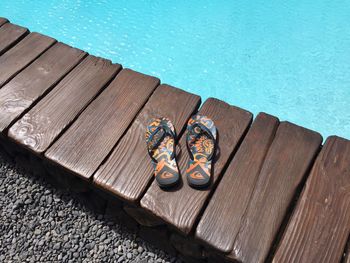 High angle view of slippers by swimming pool