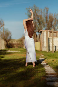 Rear view of woman standing on field