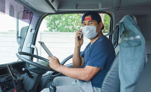 Portrait of young man sitting in car