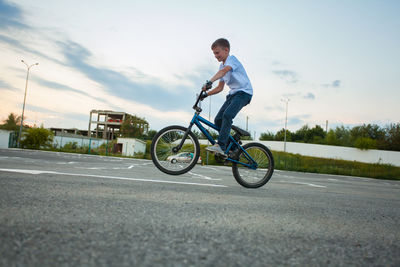 Boy riding bicycle on road