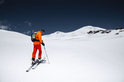 Portrait of a young male athlete skier in a ski tour on skis on the background of snow-capped