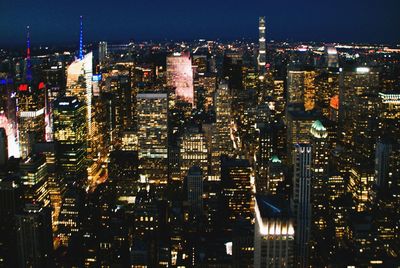 Illuminated cityscape against sky at night