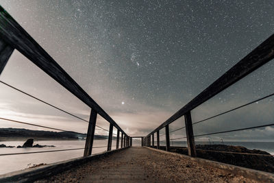 Bridge over sea against sky at night