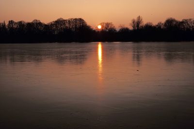 Scenic view of lake against orange sky