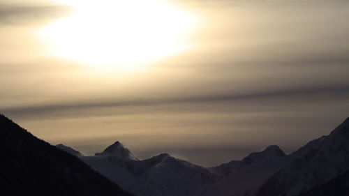 Scenic view of snowcapped mountains against sky during sunset