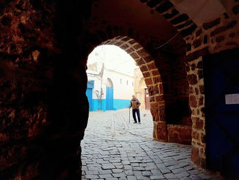 Rear view of woman walking in corridor of historic building