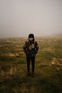 Full length portrait of man standing on field