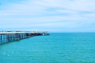 Pier over sea against blue sky