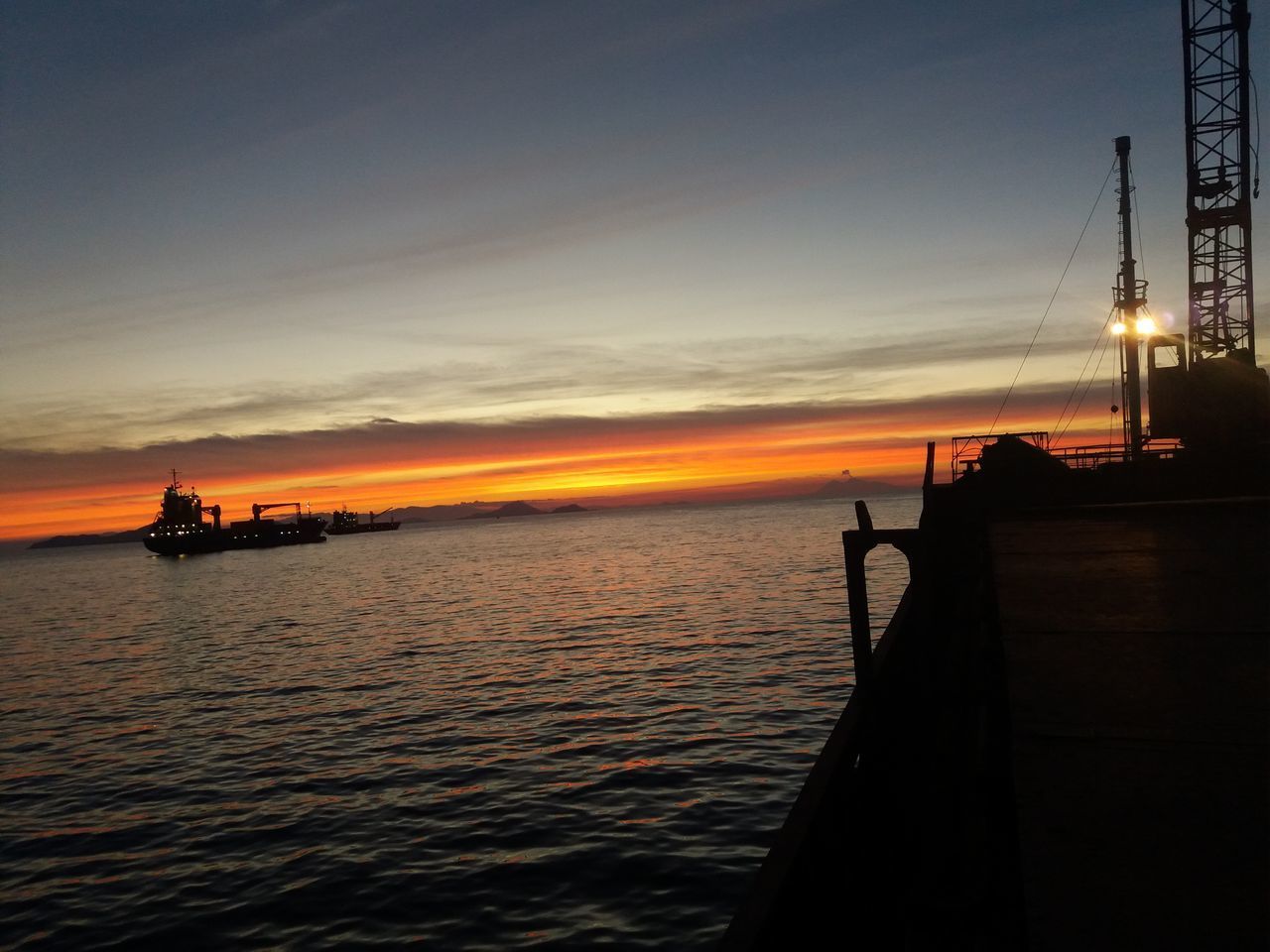 SILHOUETTE PIER ON SEA AGAINST ORANGE SKY