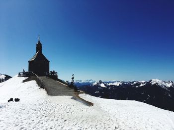 Snow covered buildings against clear blue sky