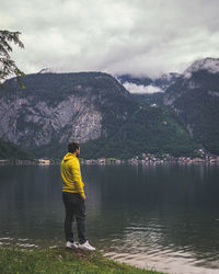 Full length of man standing by lake against sky