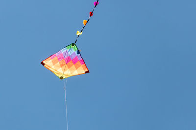 Low angle view of decoration hanging against clear blue sky