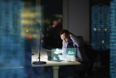 Young businessman working in office at night