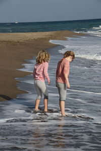 Rear view of two girls on beach