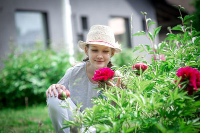Portrait of woman with pink flowers in park