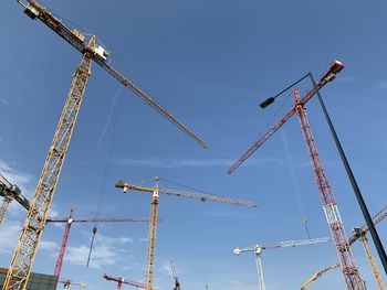 Low angle view of cranes against clear sky