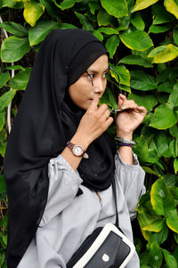 Full length of young woman holding plant