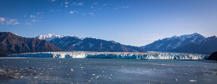 Scenic view of snowcapped mountains against blue sky