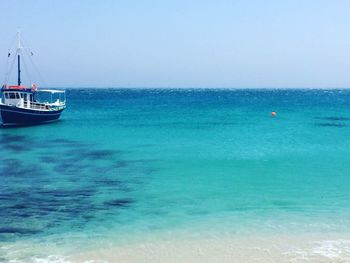 Boats sailing in sea against clear sky