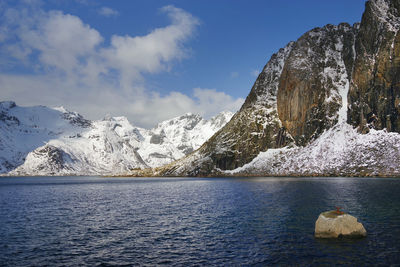 Scenic view of snowcapped mountains by sea against sky