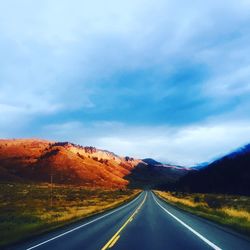 Empty road with mountain range in background