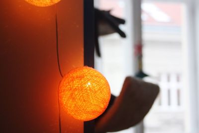 Close-up of illuminated lamp hanging against wall