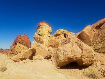 Rock formations in desert against clear blue sky