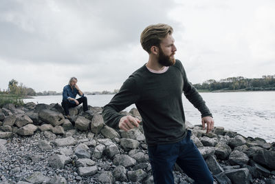 Father and son spending time together, son skipping pebbles