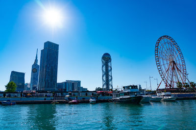 Ferris wheel in city against blue sky