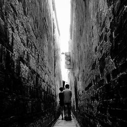 Full length rear view of woman walking in tunnel