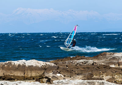 Man surfing in sea against sky