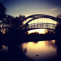 Bridge over river at sunset