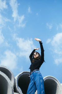 Low angle view of woman standing against sky