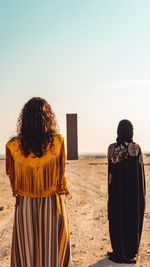 Rear view of woman looking at sea against clear sky