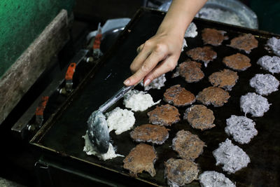 Cropped hand of woman preparing food