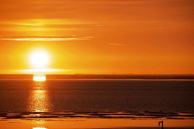 Scenic view of sea against orange sky