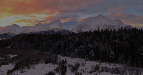 Scenic view of snowcapped mountains against sky during sunset