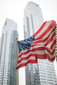 Low angle view of american flag against buildings