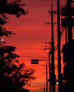 Silhouette electricity pylon against sky during sunset