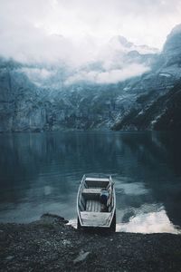 High angle view of fishing boat moored at lakeshore during foggy weather