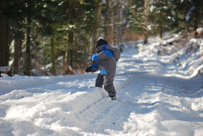 Full length of woman skiing on snow covered field