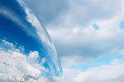 Low angle view of glass building against sky